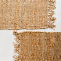 4: Two jute placemats with fringed trim.