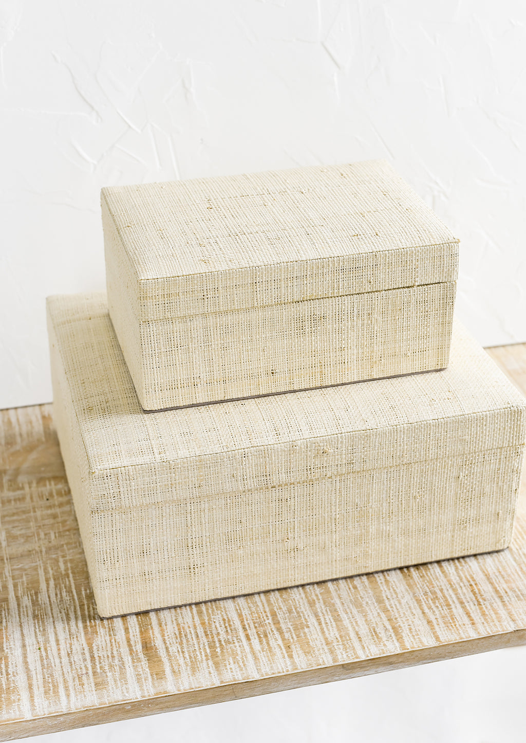 1: Small and large upholstered linen storage boxes.