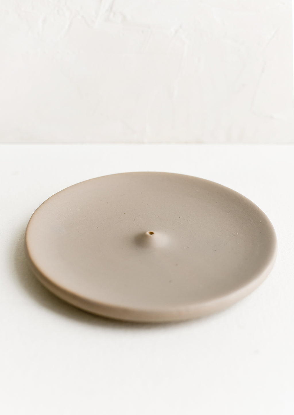 Matte Taupe: A round ceramic incense holder in matte taupe