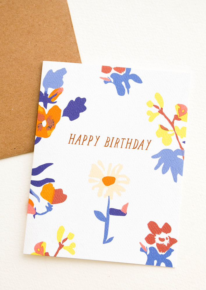 Greeting card with blue and orange flowers, "Happy Birthday" in copper text