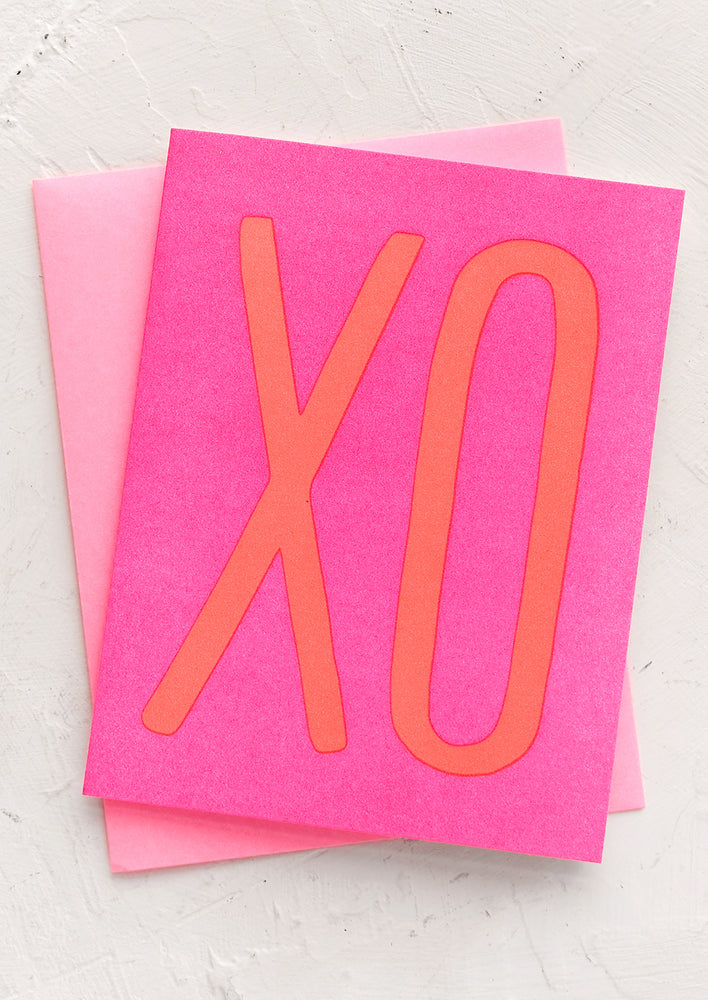 1: A neon pink card with neon orange "XO".