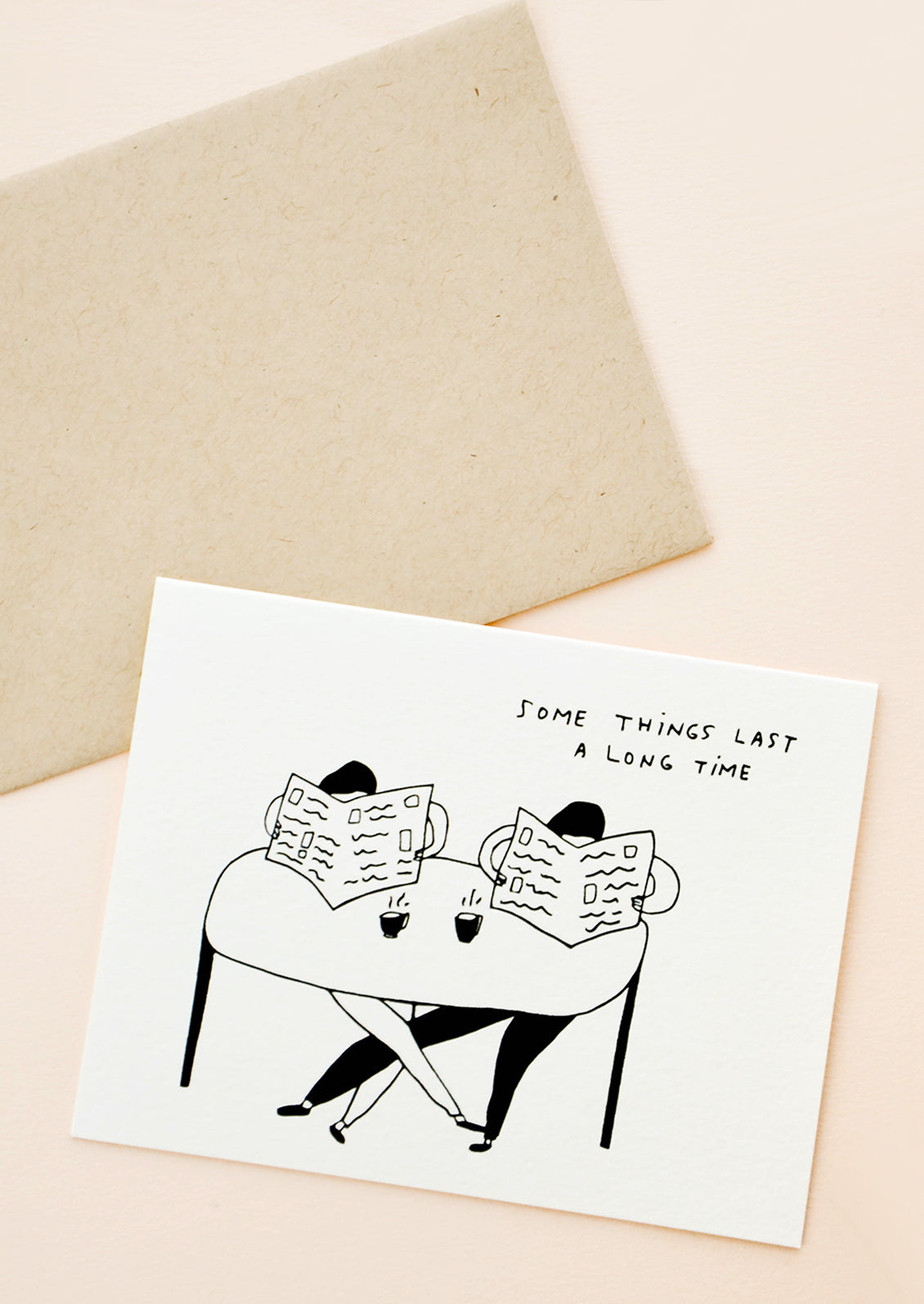 Greeting card with couple sitting at table with coffee cups and both reading newspapers, written text at corner reads "Some things last a long time"