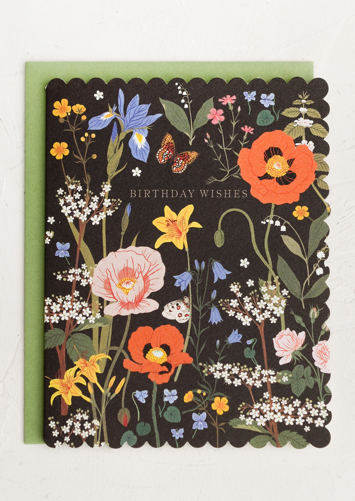 A black card with scalloped edges and floral print reading "Birthday wishes".