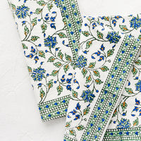 2: A pair of block printed floral napkins in green, blue and orange pattern with border.