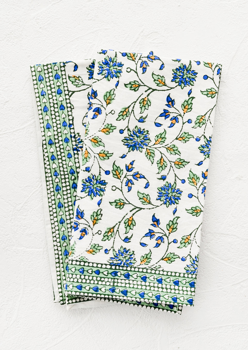 1: A pair of block printed floral napkins in green, blue and orange pattern.