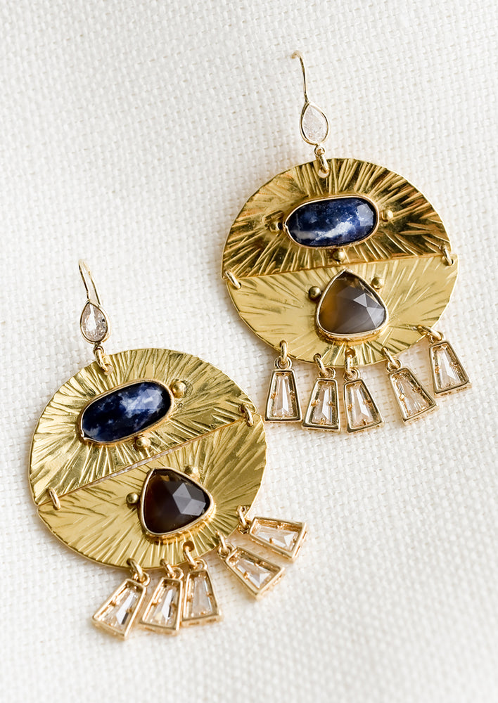 1: A pair of round textured gold earrings with gemstone and dangling crystal detailing.
