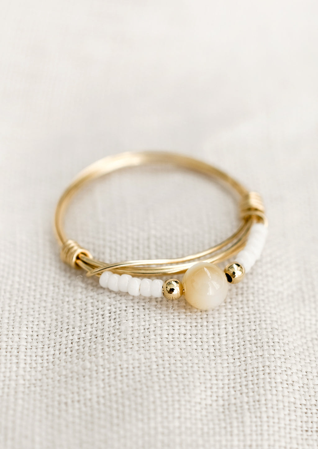 Size 5 / White: A gold wire ring with white and tan beads.