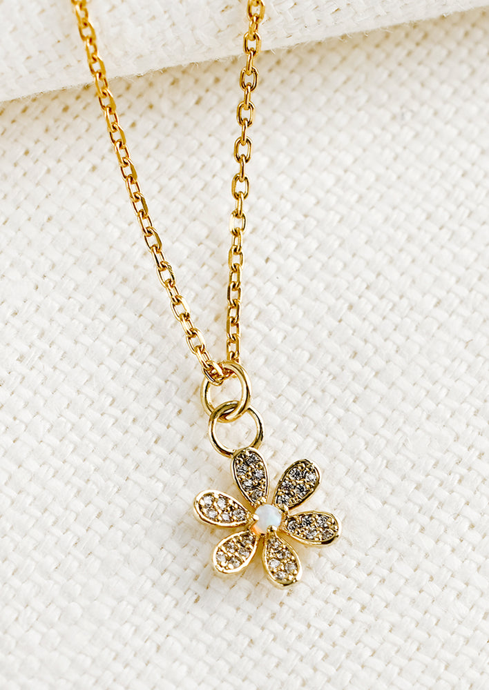 1: A gold necklace with single flower charm.
