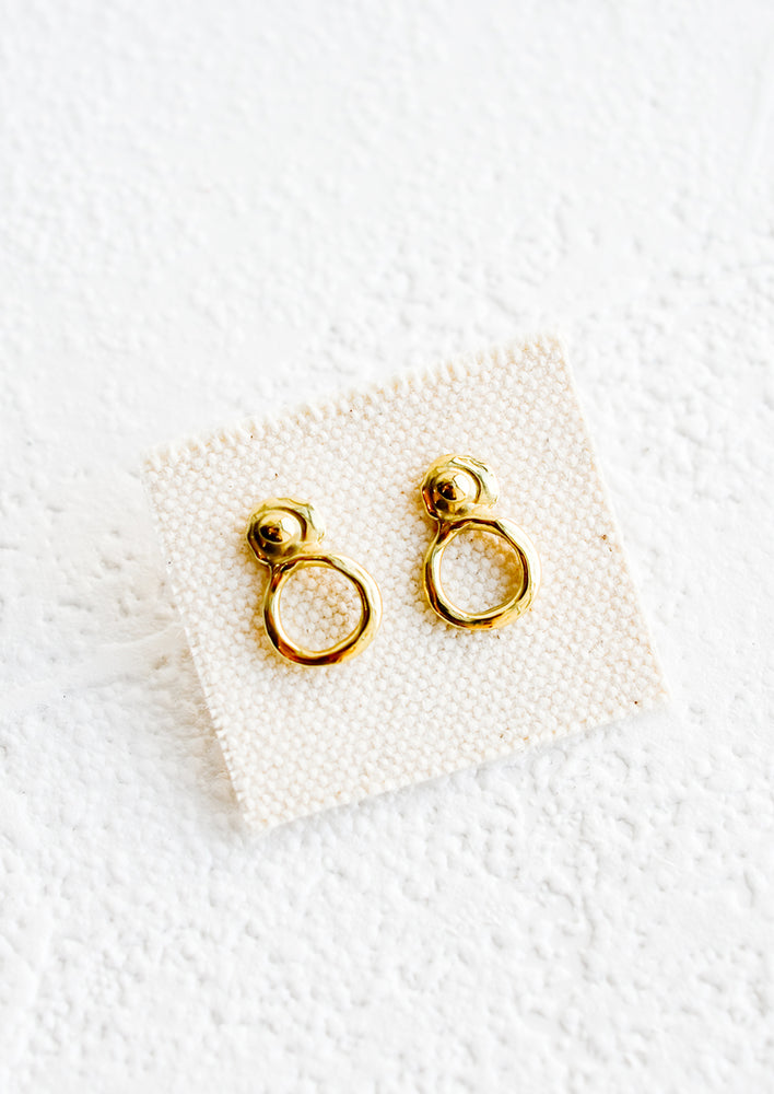 1: A pair of small brass stud earrings with an organic wabi sabi post and circular bottom.