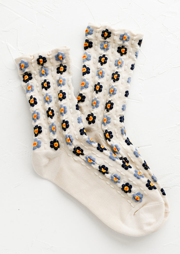 1: A pair of ivory socks with blue flowers.