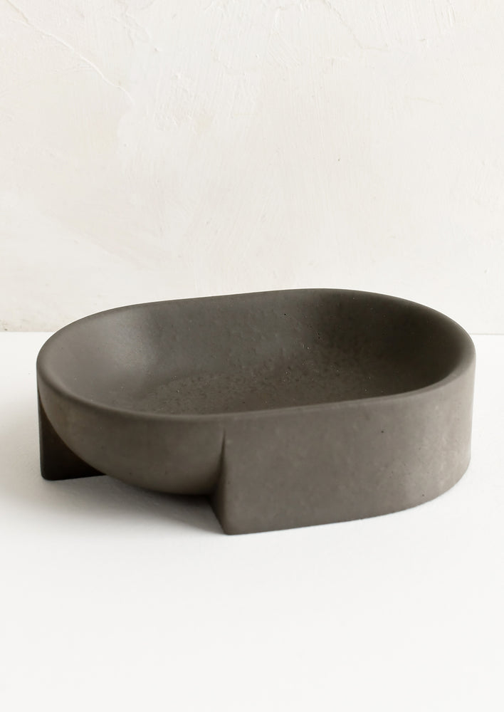 A modern oval-shaped dish in charcoal concrete.