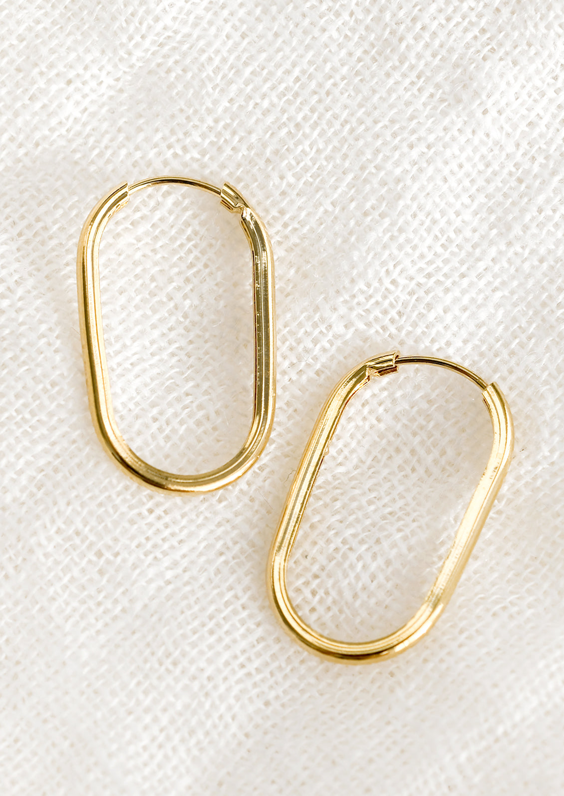 A pair of oval shaped, endless loop earrings.