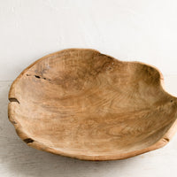 2: A large teak wood bowl with natural cracks and fissures.