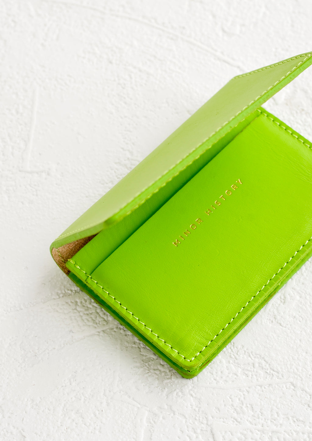 Lime: A lime green leather card holder wallet with interior sleeve and gold branding.