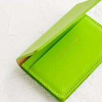Lime: A lime green leather card holder wallet with interior sleeve and gold branding.
