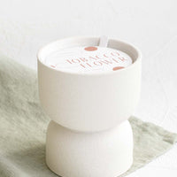 Tobacco Flower: Scented candle in hourglass-shaped matte ceramic containers in white