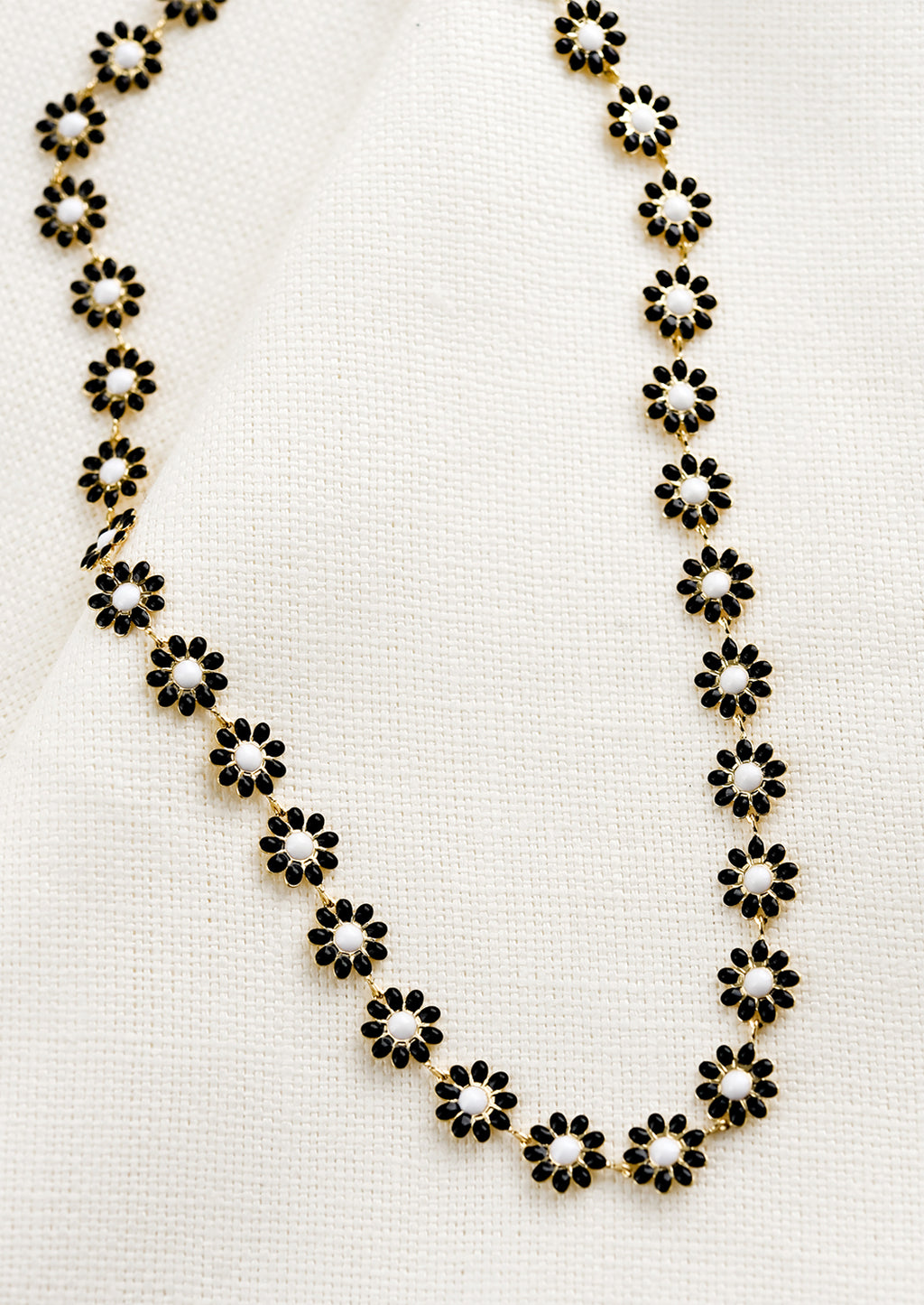 Black: A necklace with allover black and white enamel flowers.