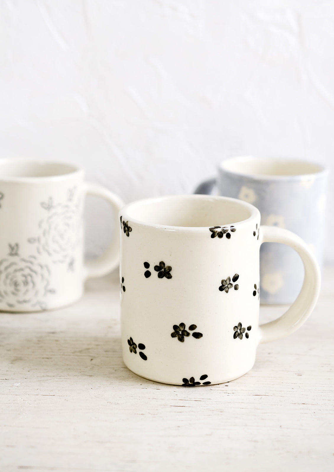 Handmade ceramic mugs in a variety of floral patterns and colors.