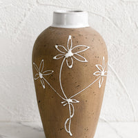 2: A brown clay vase with white floral sketch.
