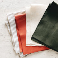 Tomato: Linen Napkins splayed out in an array of colors.