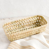 Narrow: A shallow, narrow storage basket made from dried palm leaf.