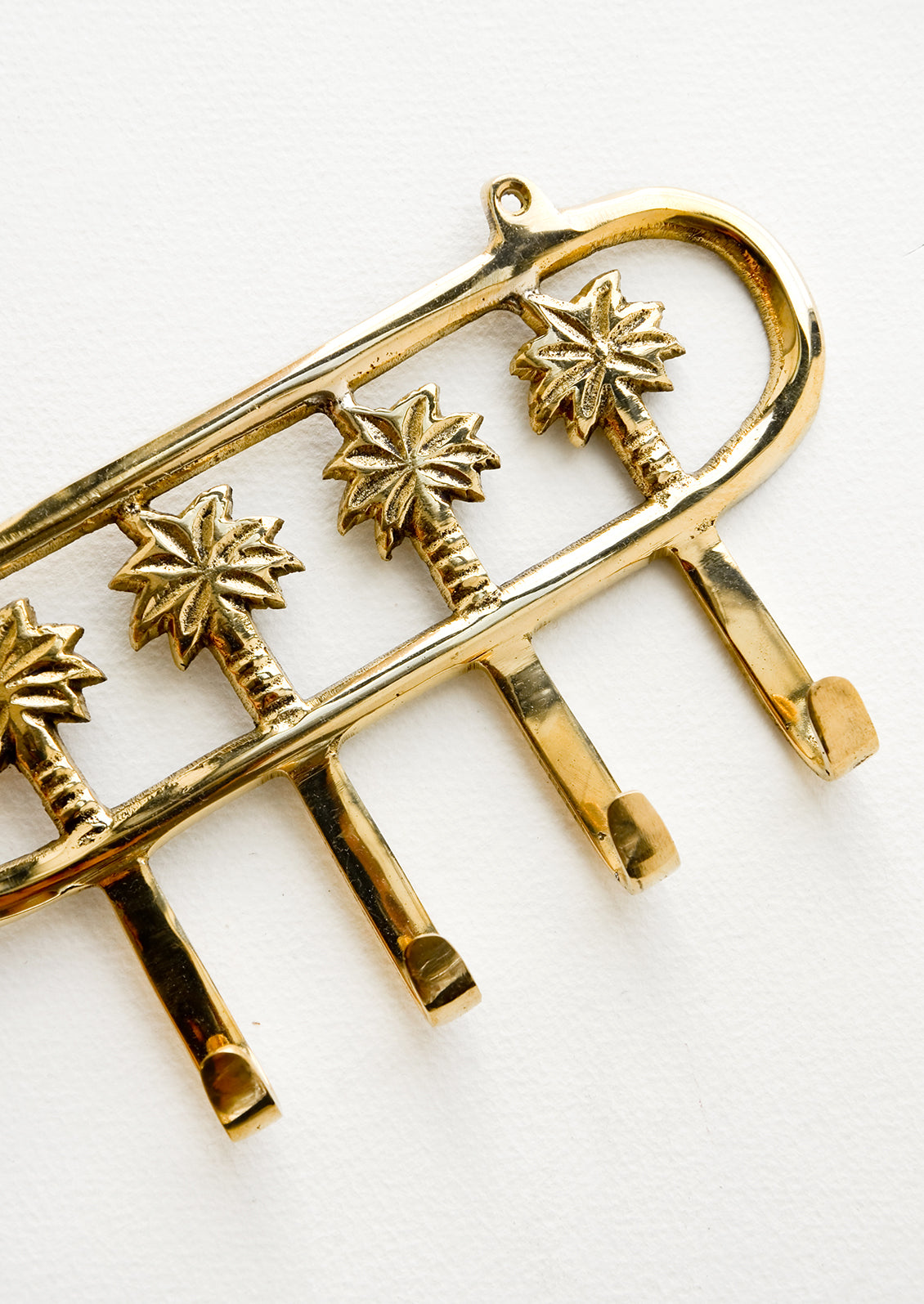 Wall mountable hook rack with 4 palm trees extending into hooks, made in brass
