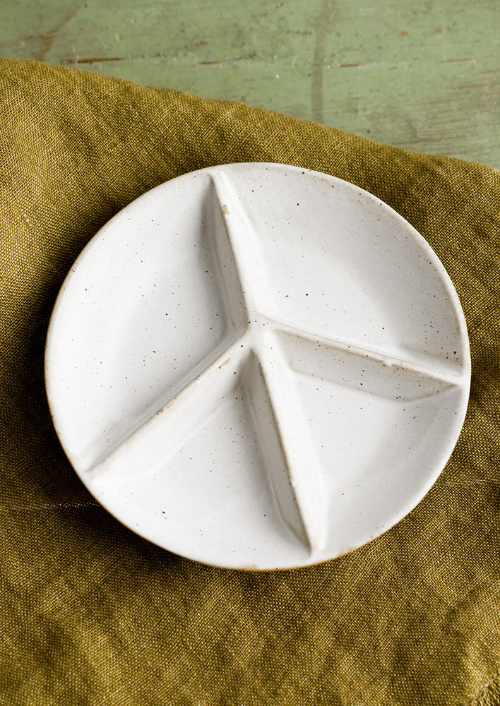 1: A white ceramic dish with peace sign divider.