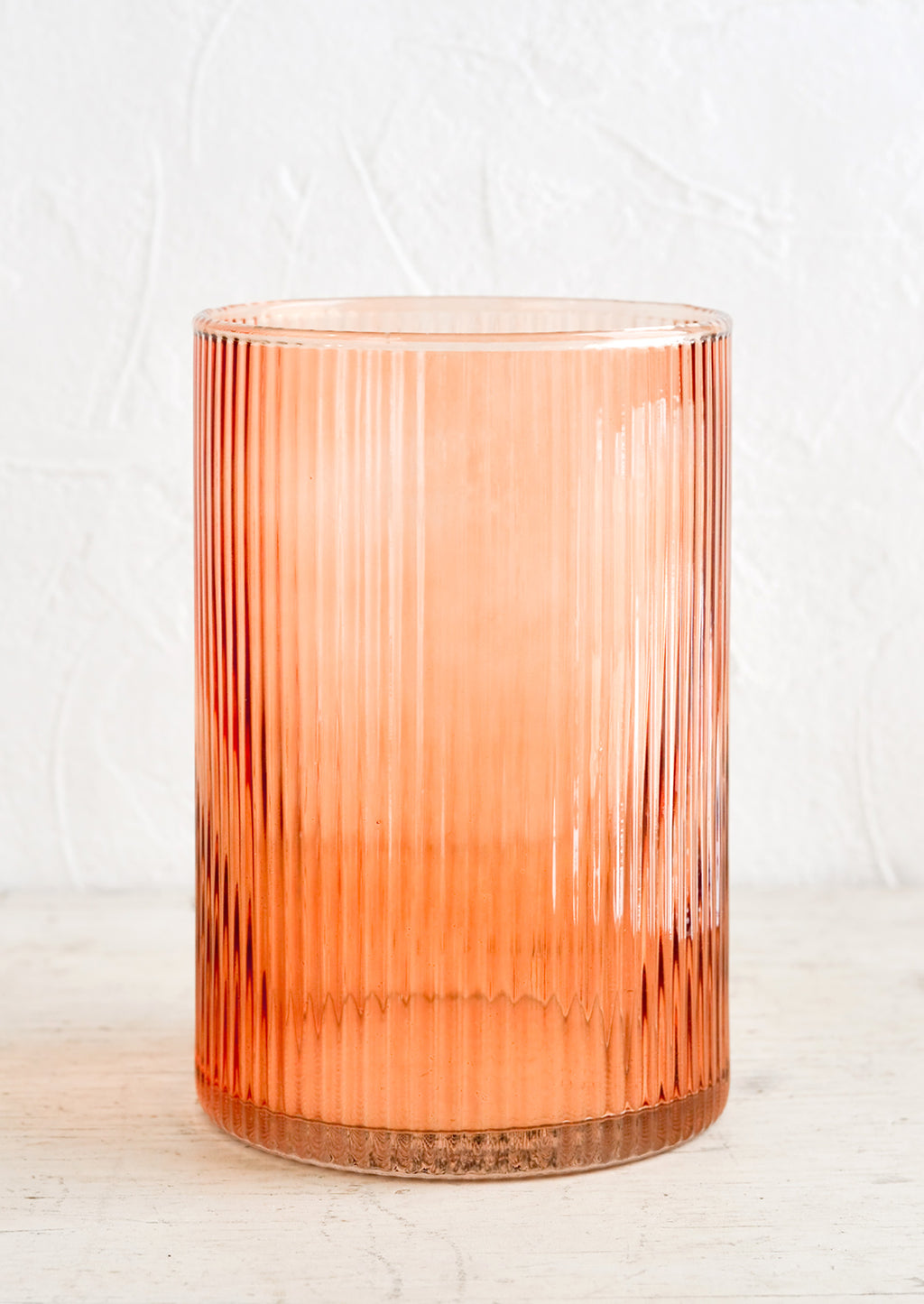 Tall: A fluted glass hurricane vase in peach color.