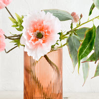 4: A fluted peach glass vase with pink and green flowers.