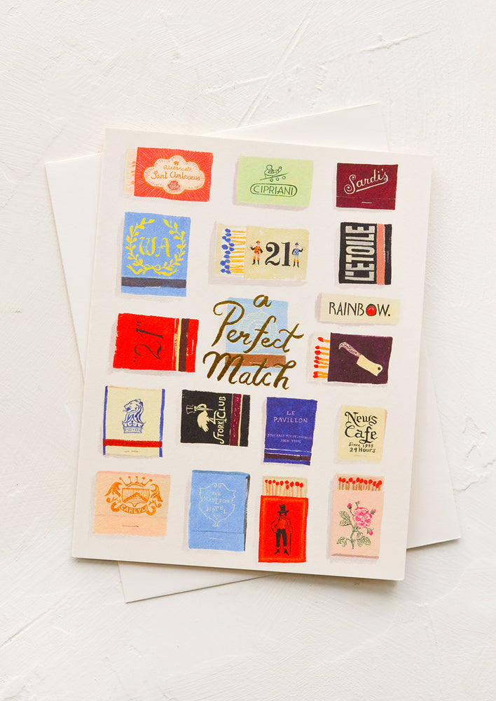 1: A greeting card with matchbox print and gold lettering "A perfect match".