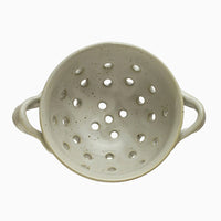 3: A small speckled ceramic berry colander with side handles.