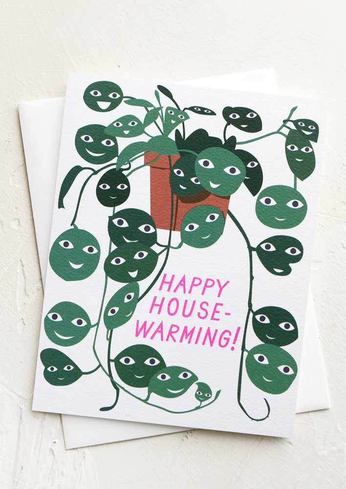 Greeting card with plant with faces on leaves, reads "Happy Housewarming!".