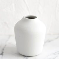 White: A white porcelain bud vase.