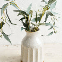 Natural: A glossy ceramic vase in natural speckled color, with eucalyptus leaves.