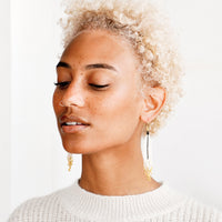 3: Model shot featuring woman wearing earrings and white top.