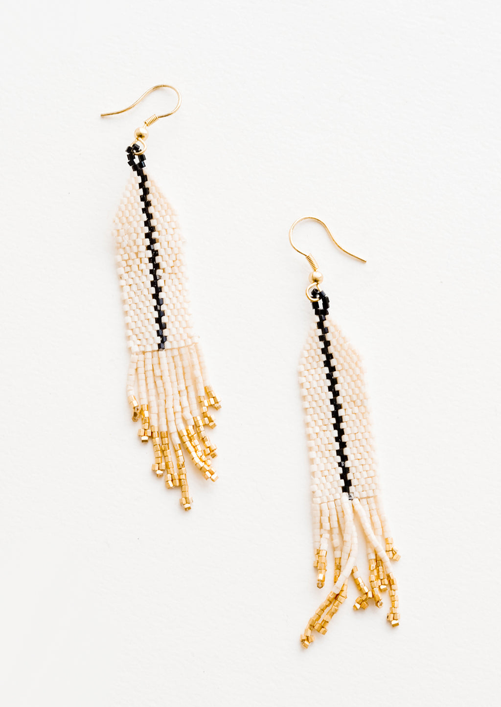 Ivory: Dangling beaded earrings with white beads accented with black bead stripe and gold bead fringe.
