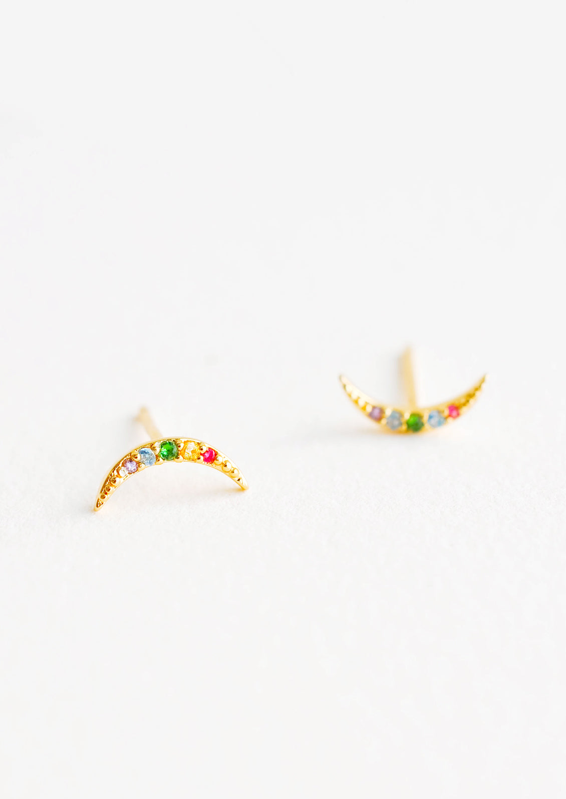 Moon-shaped stud earrings featuring inset multicolored crystals.