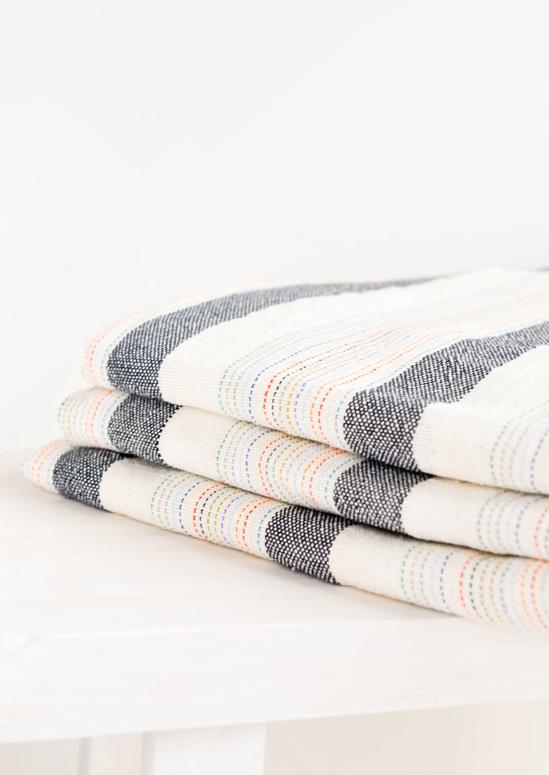 Stack of Cotton Turkish Towel in Natural & Charcoal with Rainbow Colored Stitching - LEIF