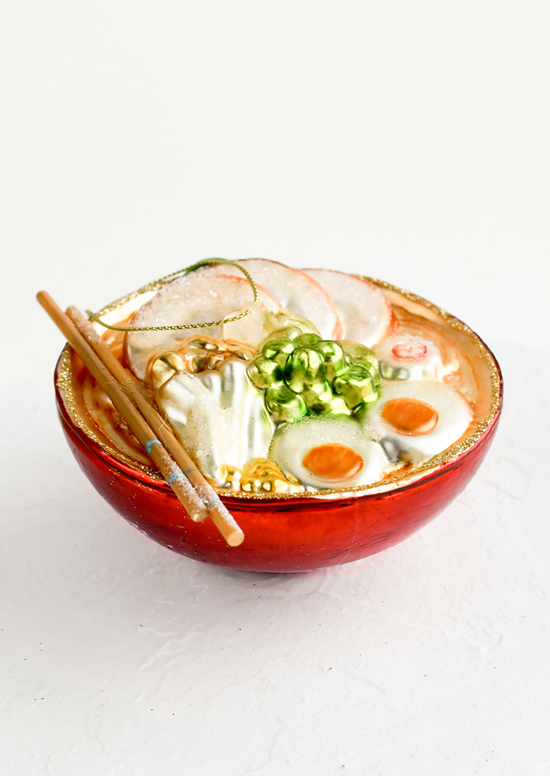 A decorative glass ornament in the shape of ramen noodle bowl.