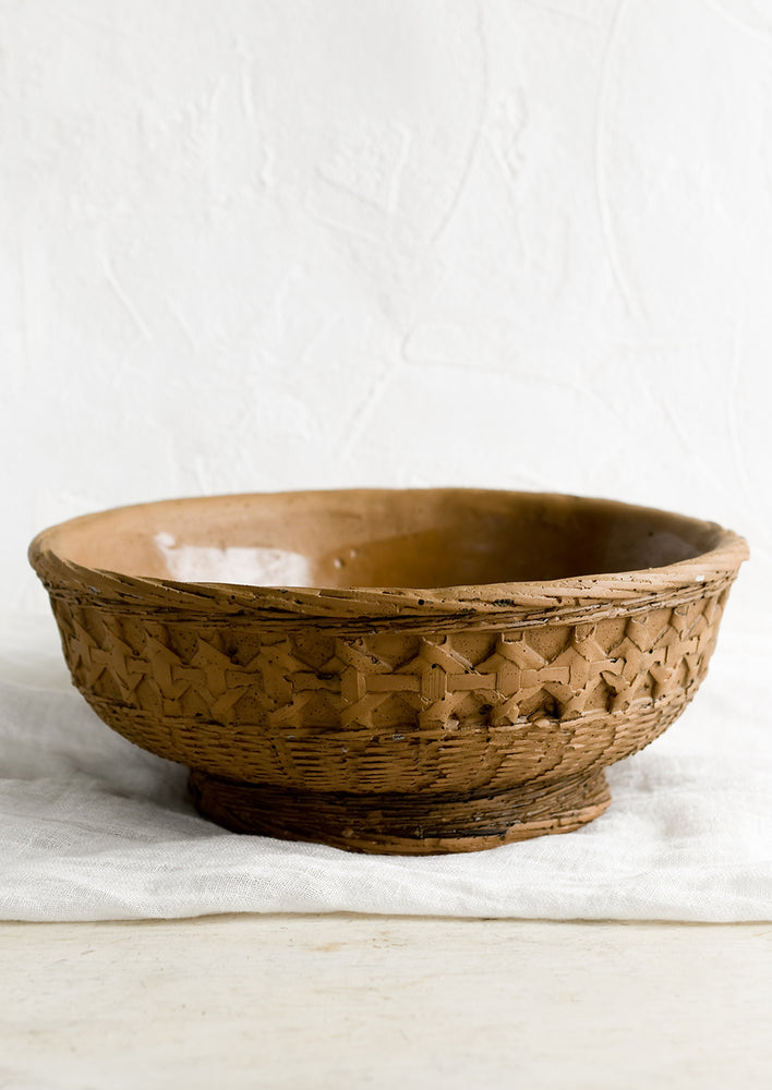 1: A brown ceramic bowl with rattan basketweave motif.