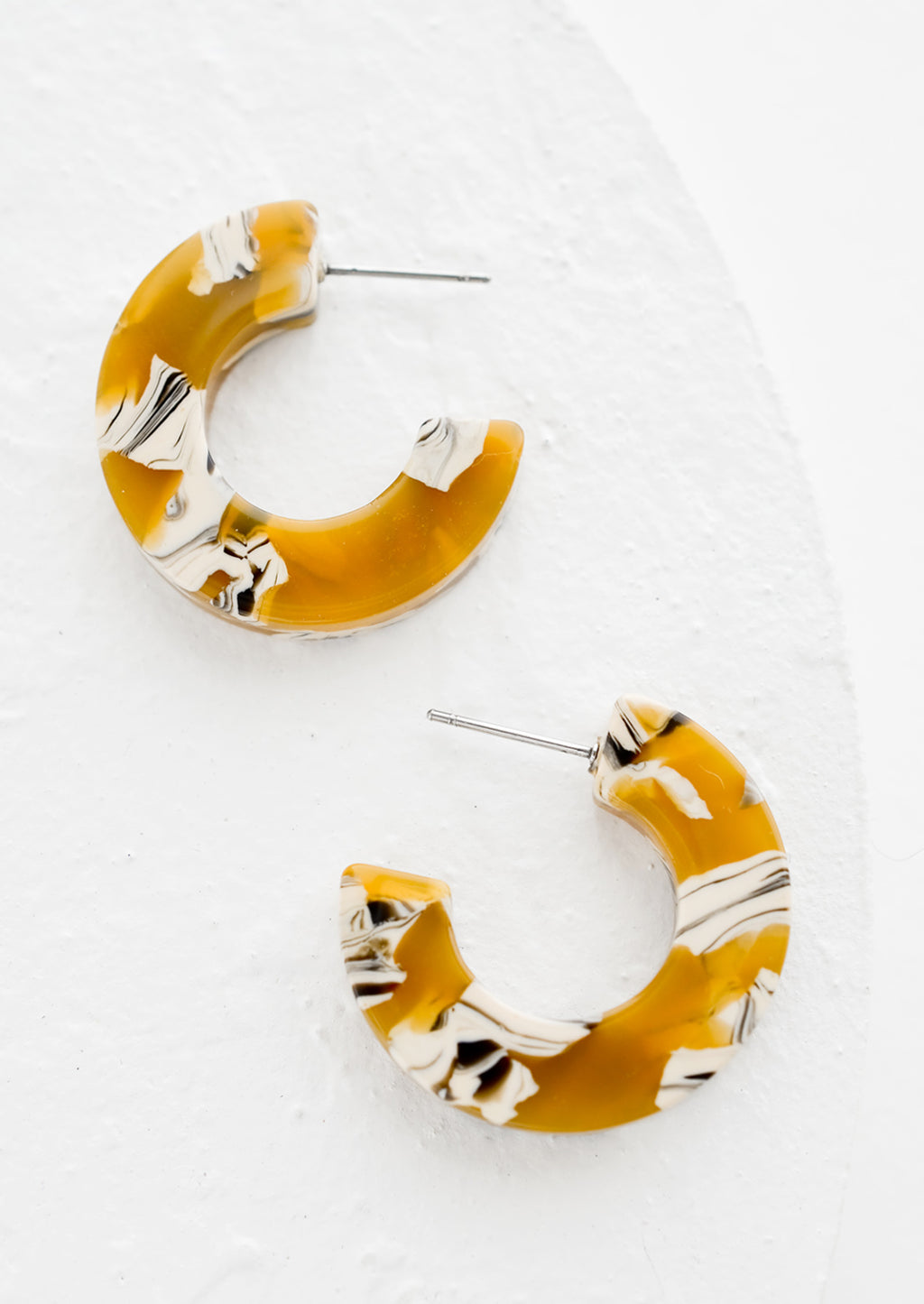 Daisy Multi: A pair of acetate hoop earrings in butterscotch.
