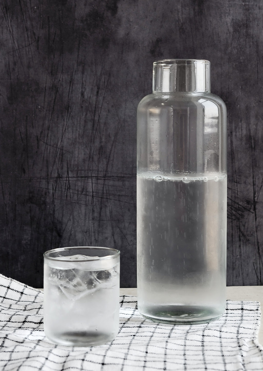1: A tall glass decanter with small matching cup.