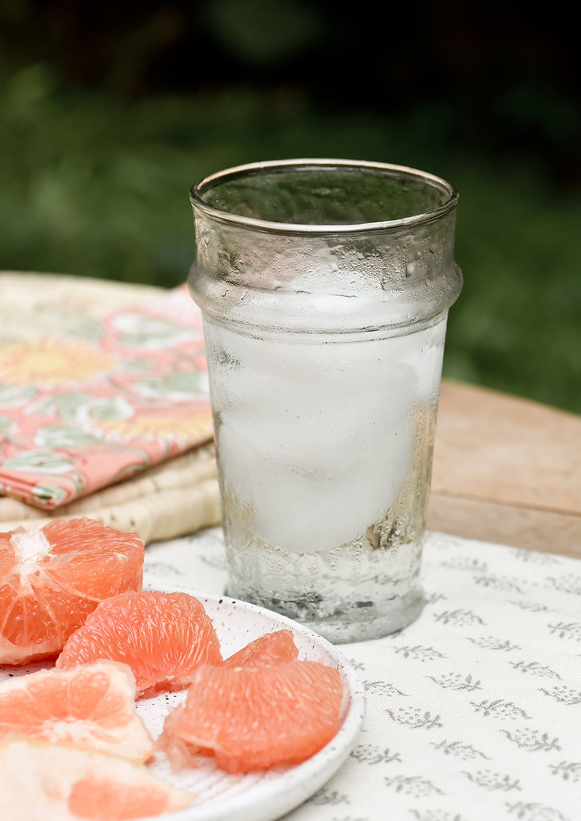 A table setting with tall glass tumbler holding ice water.