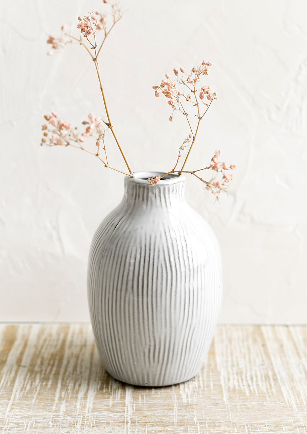 1: A curvy ceramic vase in white with brown etched stripes.