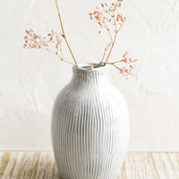 1: A curvy ceramic vase in white with brown etched stripes.