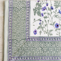 1: A block printed floral tablecloth in purple and green floral.