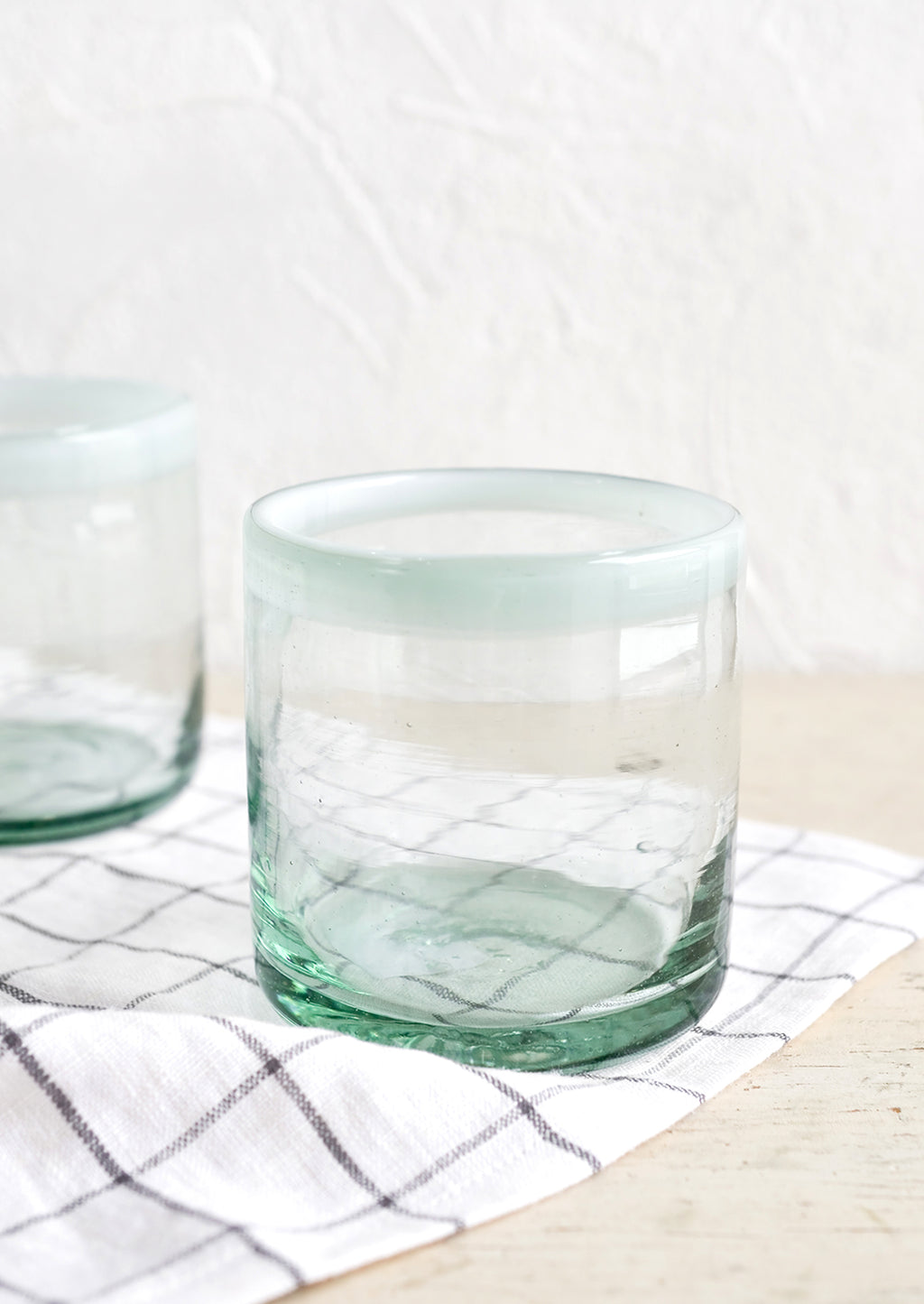 Blanco: A heavy rocks glass in natural glass with opaque white rim around top.