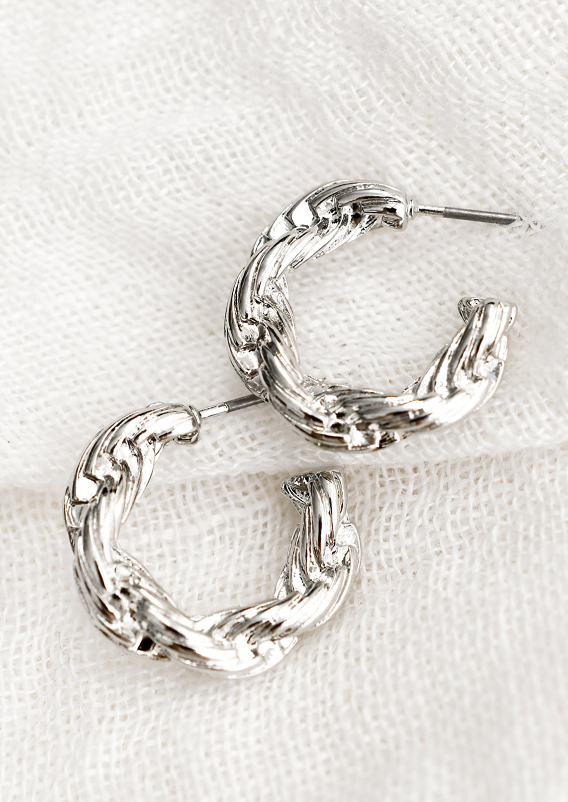 A pair of silver-tone hoop earrings with twisted rope texture.