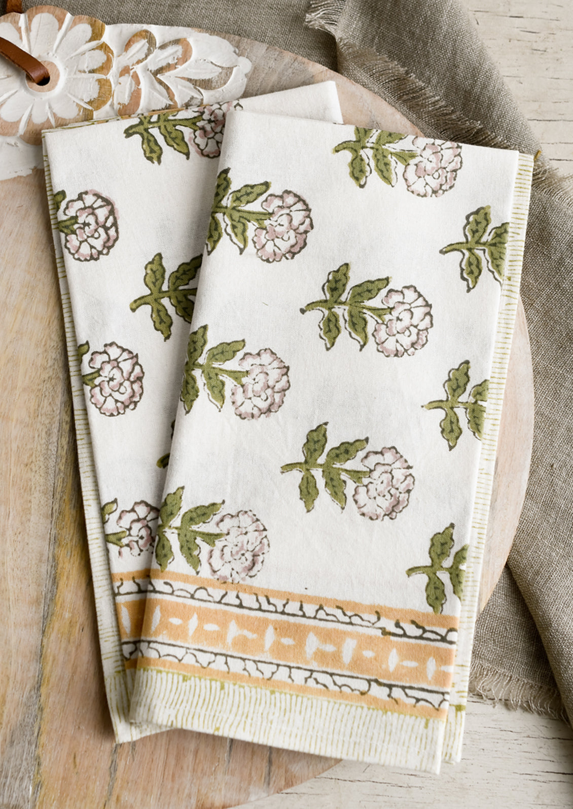 A pair of block printed floral napkins in green, mustard and lavender palette.