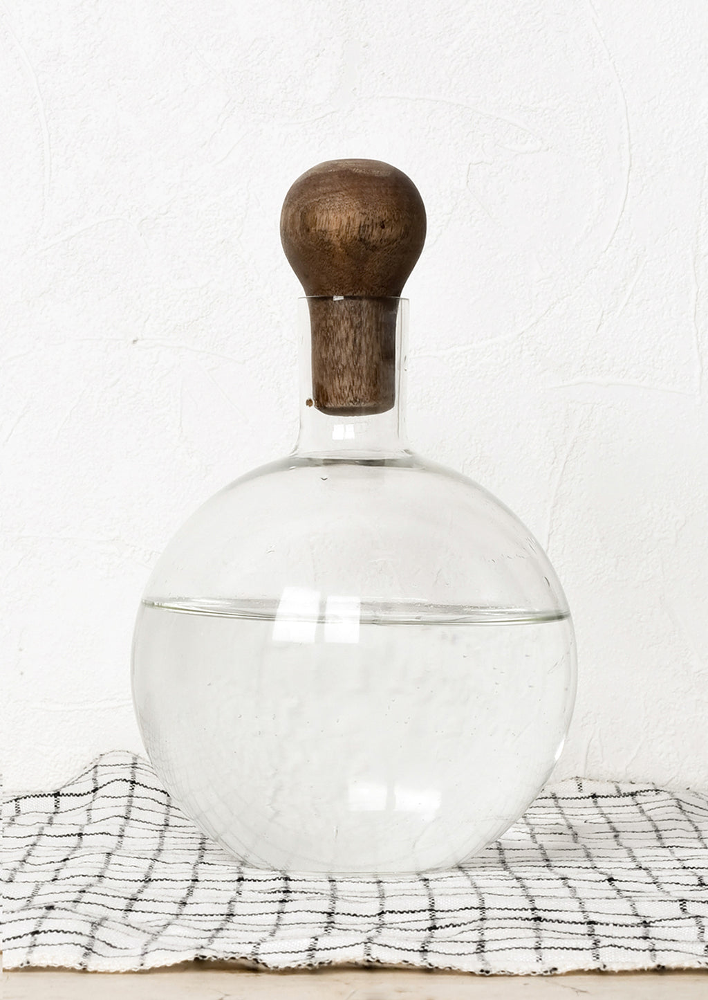 1: A glass decanter in round shape with dark wooden stopper.